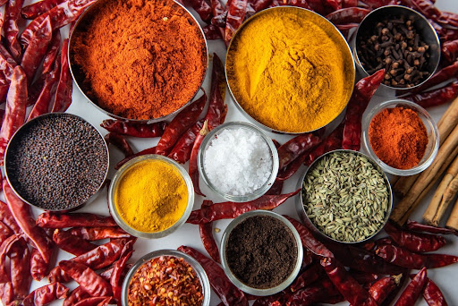 Vários temperos naturais em cima da mesa com pimentas ao redor